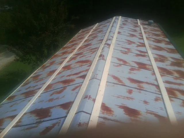 Rusted metal roof panels with new wood purlins before replacement — Storm Damage Roof Repair in Cades by Roofing Brothers